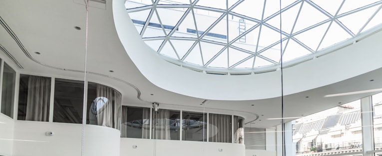 A spacious atrium featuring a prominent circular skylight that illuminates the area with natural light.
