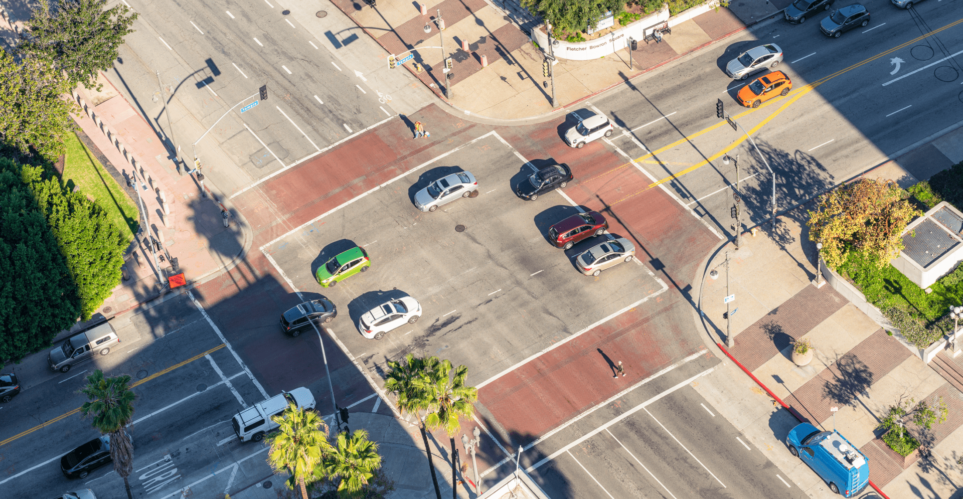 Aerial view of a bustling intersection filled with cars, showcasing the flow of traffic in a busy urban area.