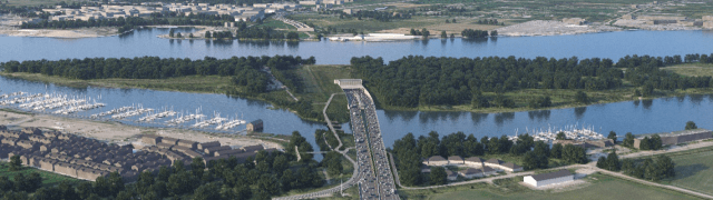 Aerial view of a city featuring a serene lake and a prominent bridge connecting two urban areas.