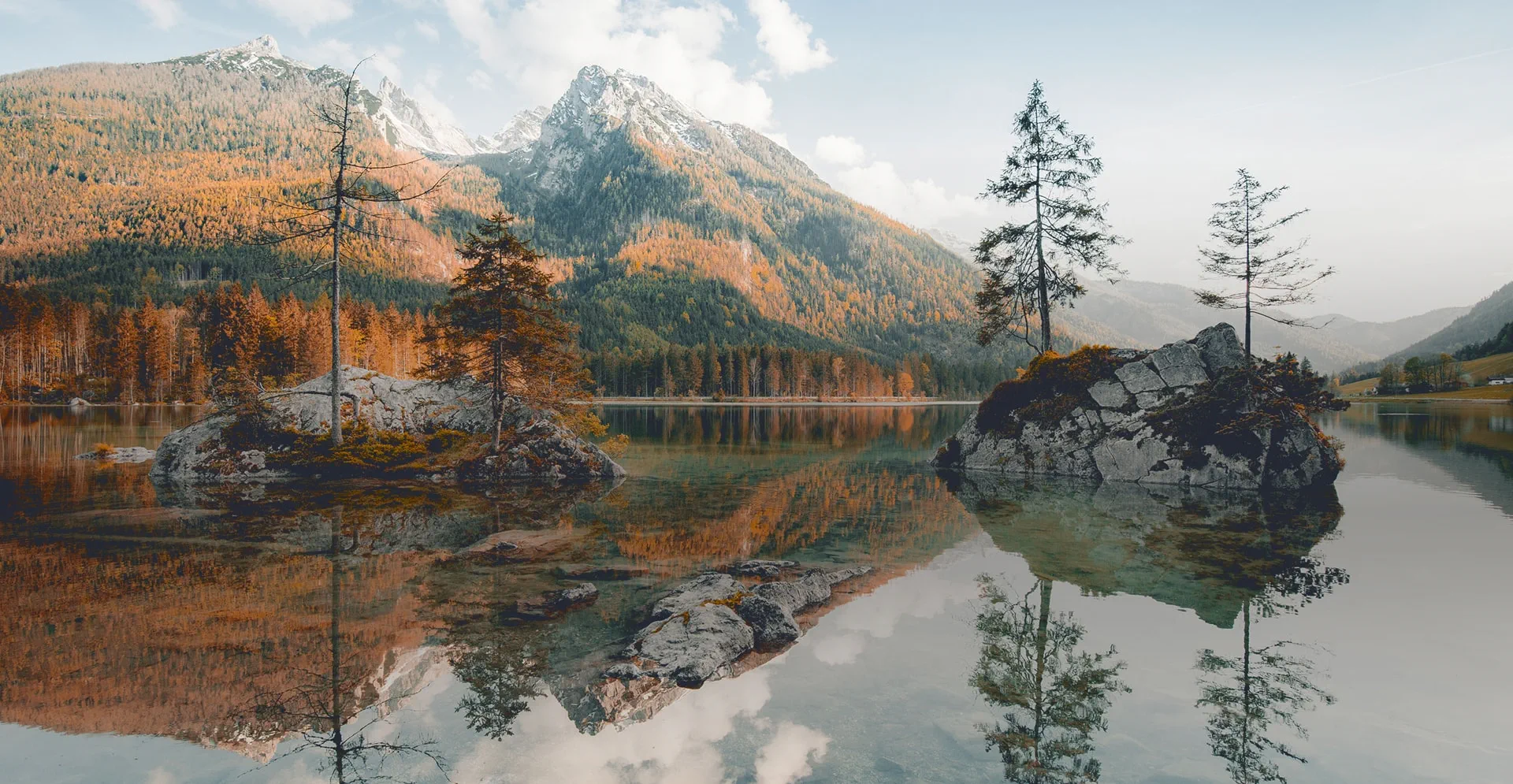 Gebirgssee mit Bergen und Wäldern im Hintergrund